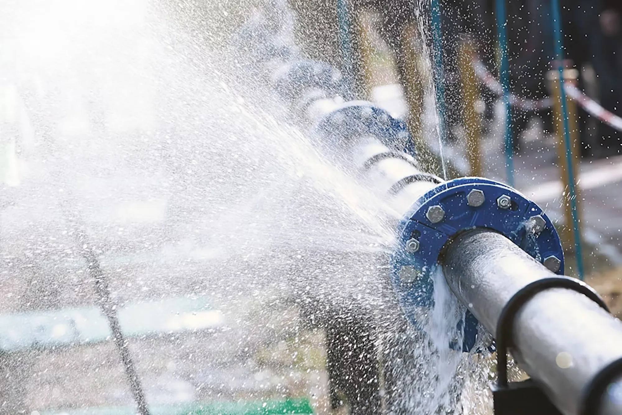 Ein Rohr, dass undicht ist und aus dem Wasser quer durch das Bild schießt