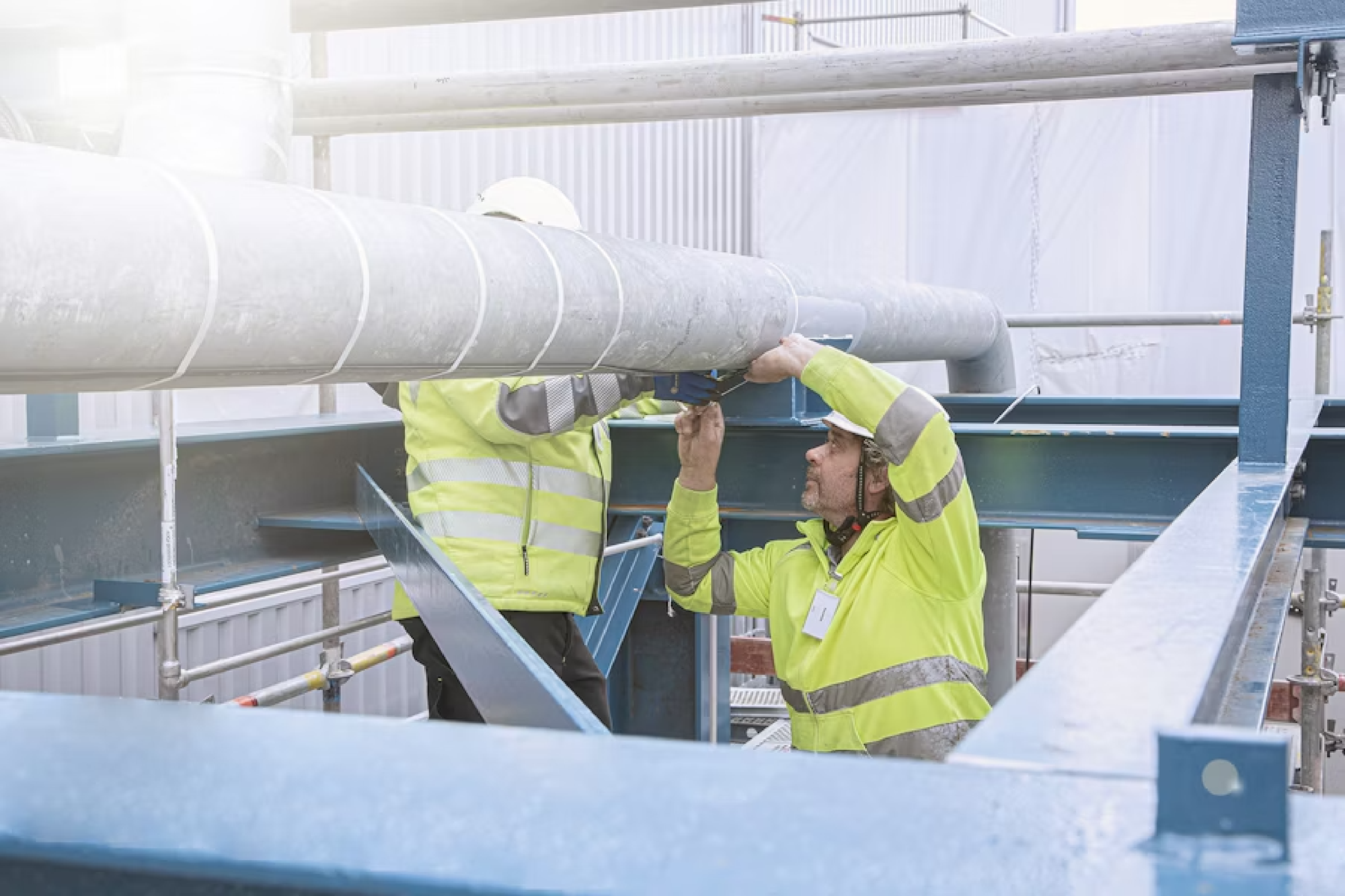 Zwei Männer bauen an einem Rohr