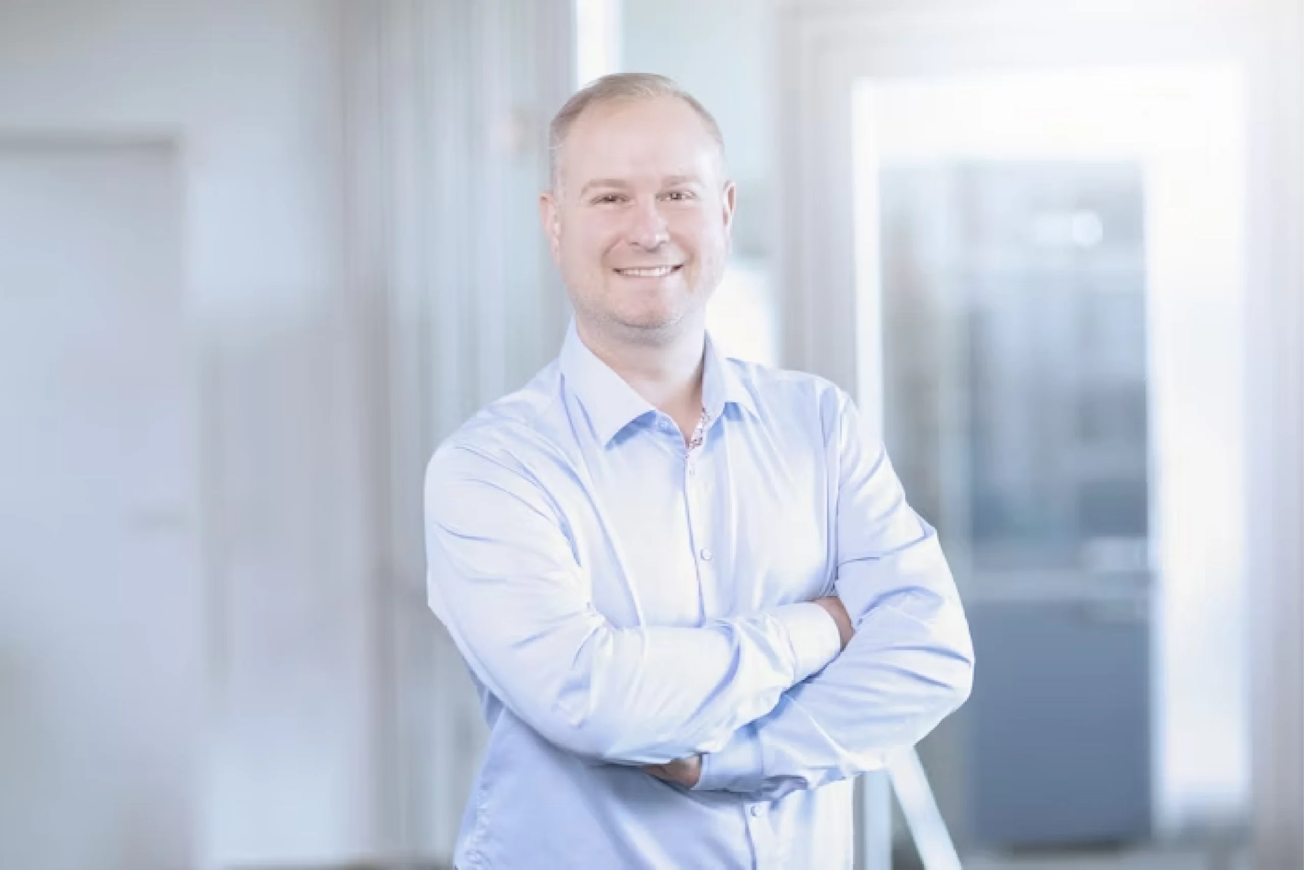 Ansprechpartner Stefan Ziegler lächelt mit verschränkten Armen in die Kamera